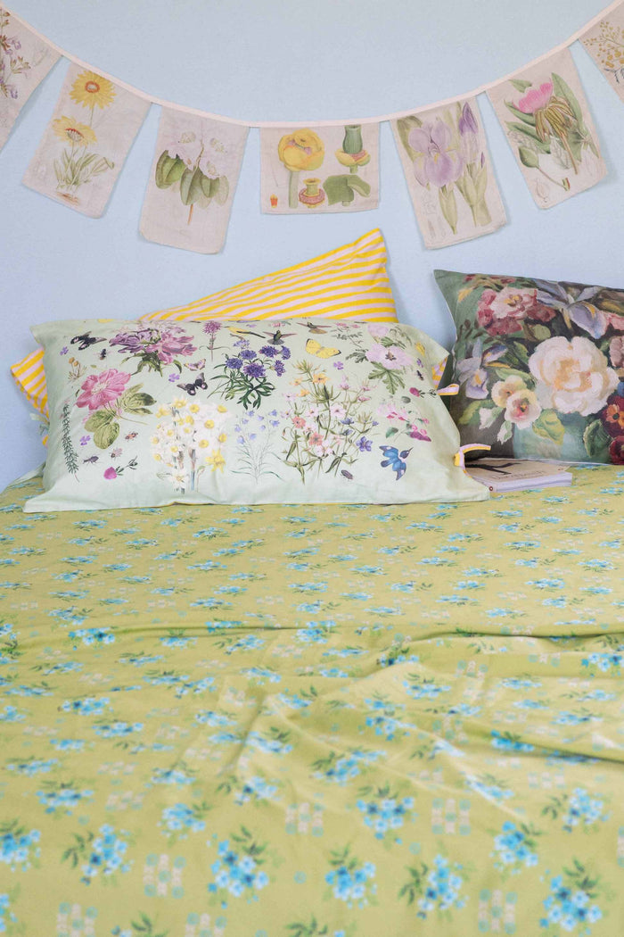 Matilda Smith Garland painted floral sheets & cushions in a busy garden.