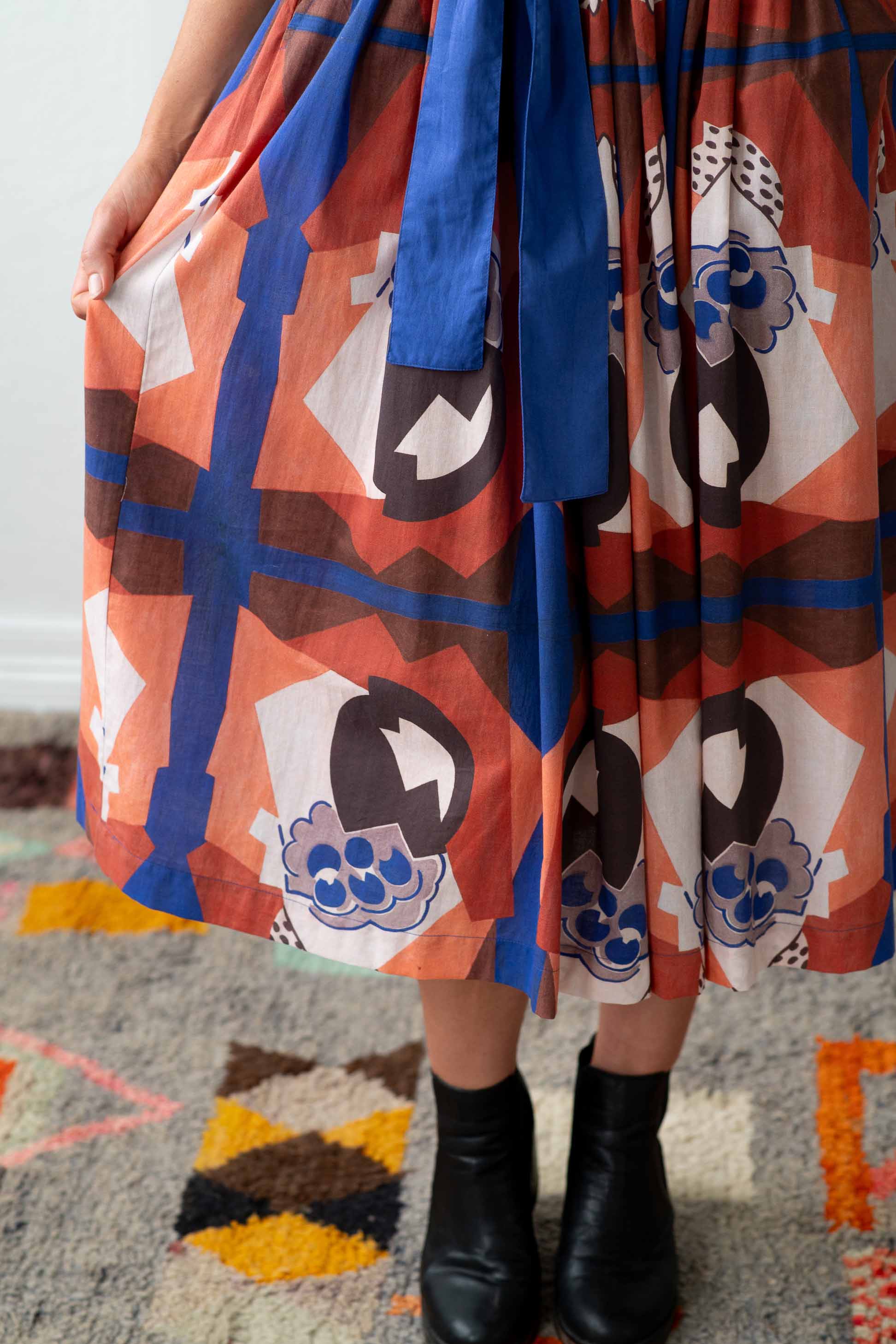 Michaela dress with blue sash and geometric pattern