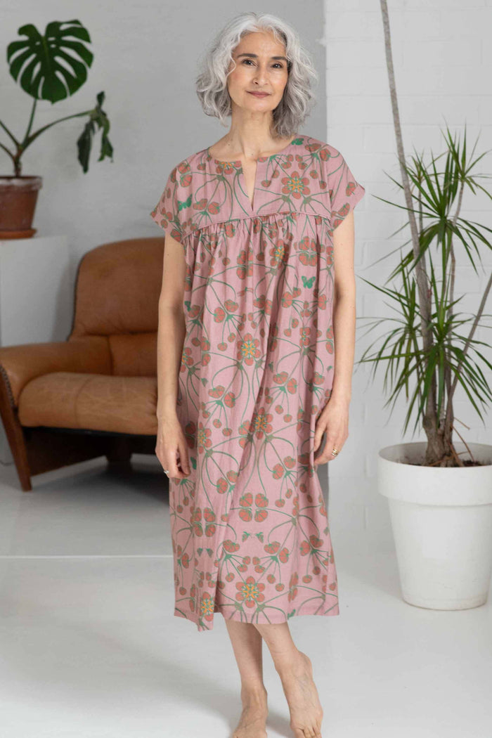 Woman in floral dress standing in room