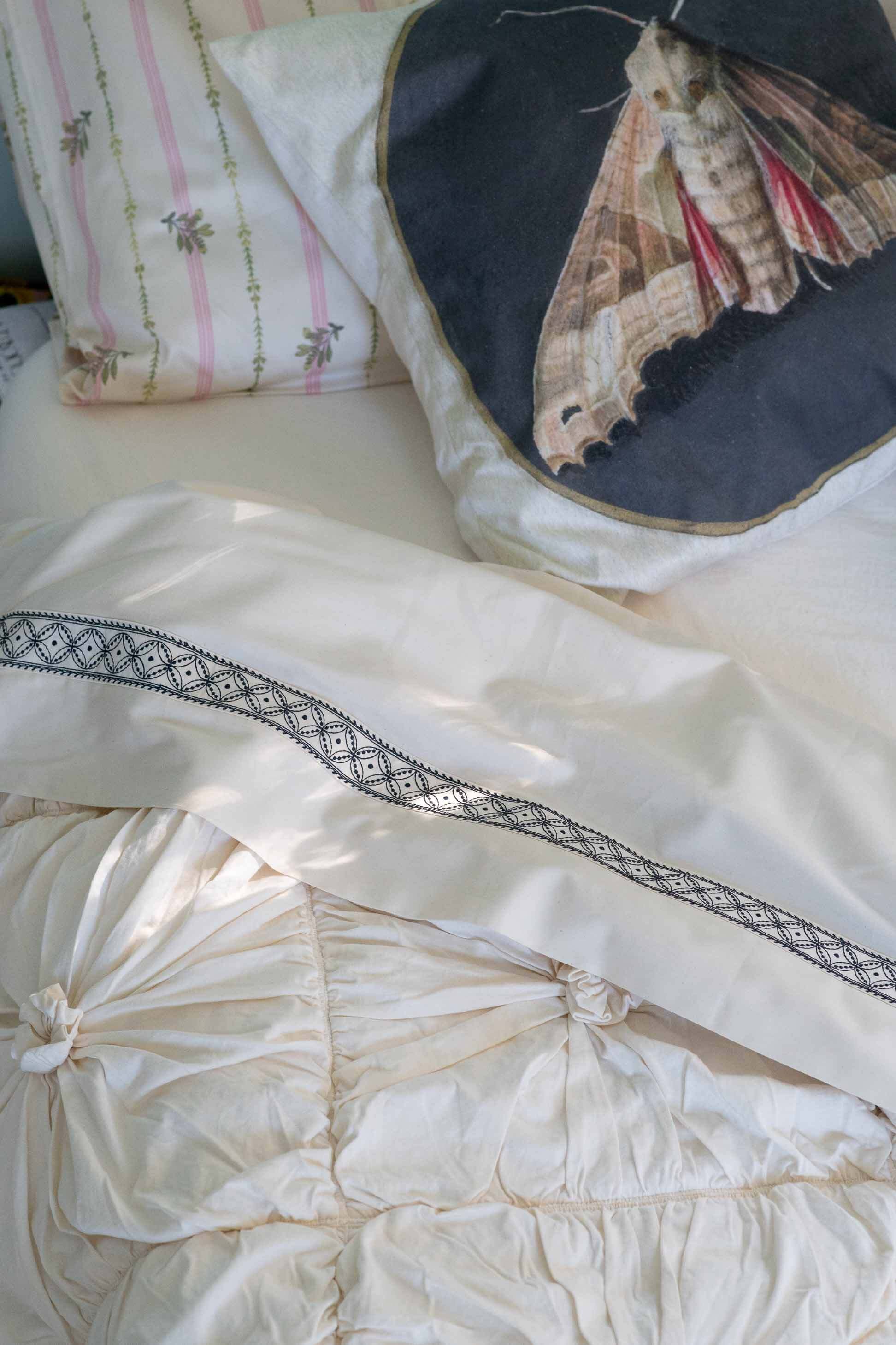 Moth on natural rosette bedding with La Belle sheets and cushion
