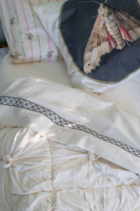 Moth on natural rosette bedding with La Belle sheets and cushion