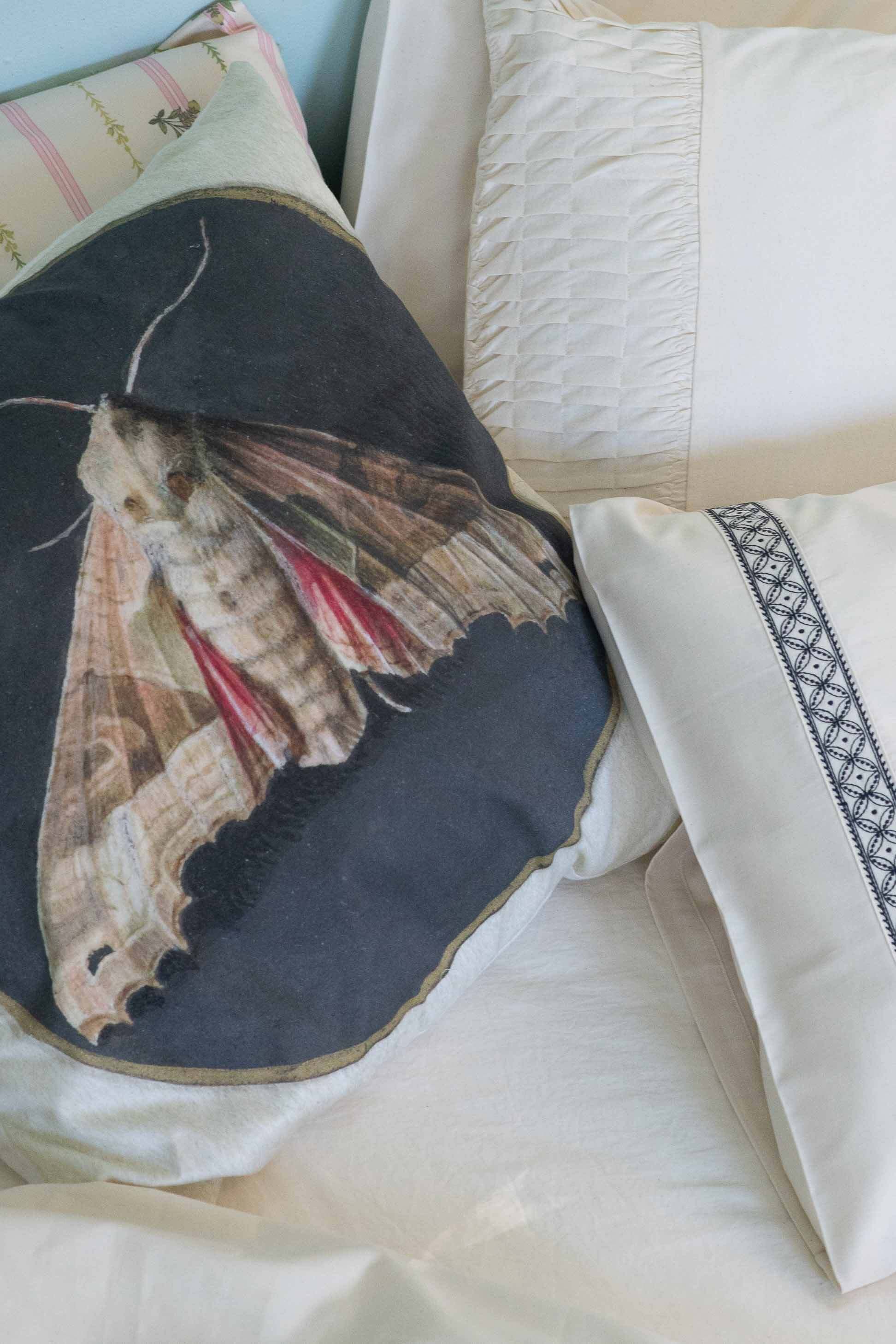 Moth cushion on La Belle sheets, rosette design, natural textiles.