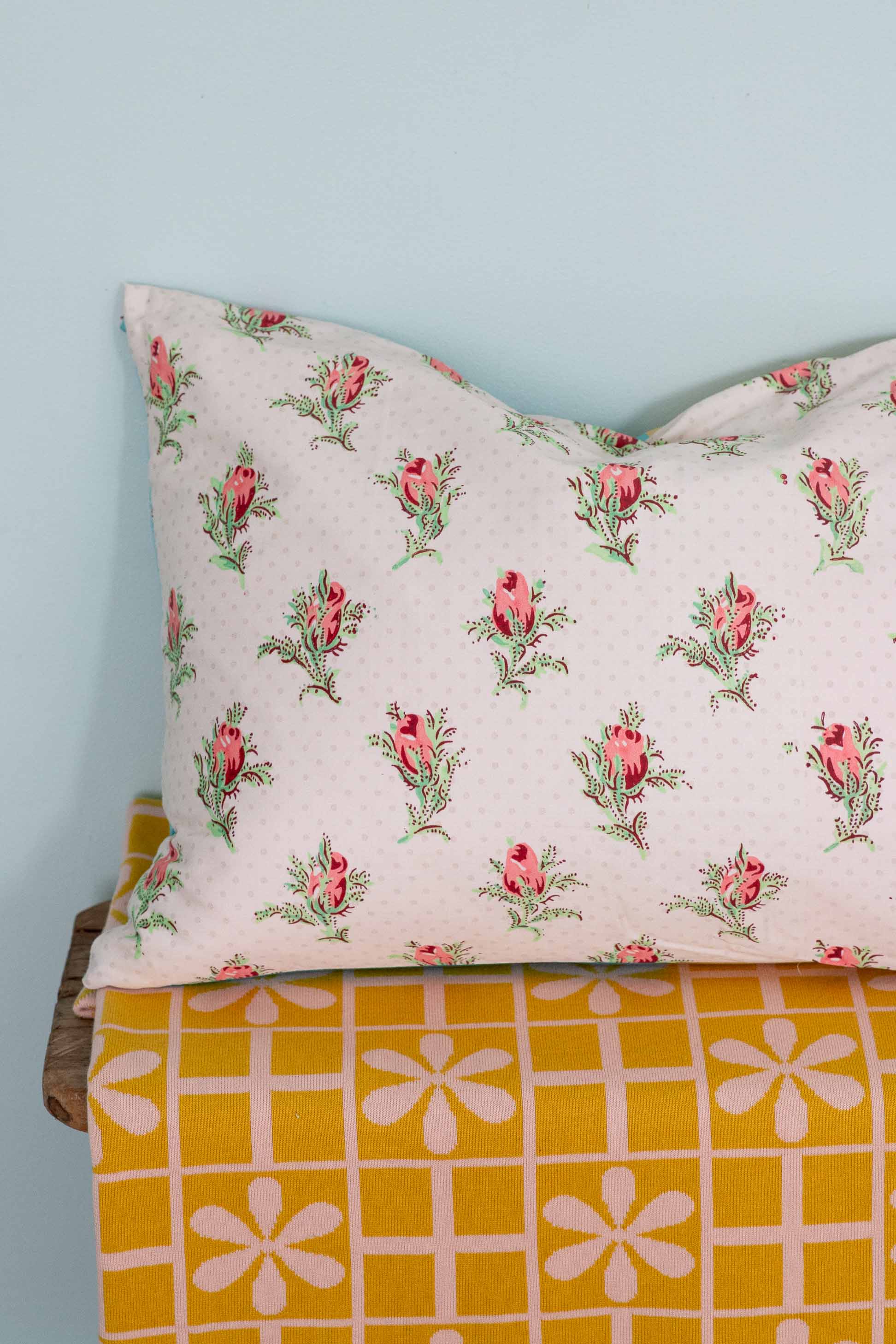 Peony & daisy floral pillow on yellow throw