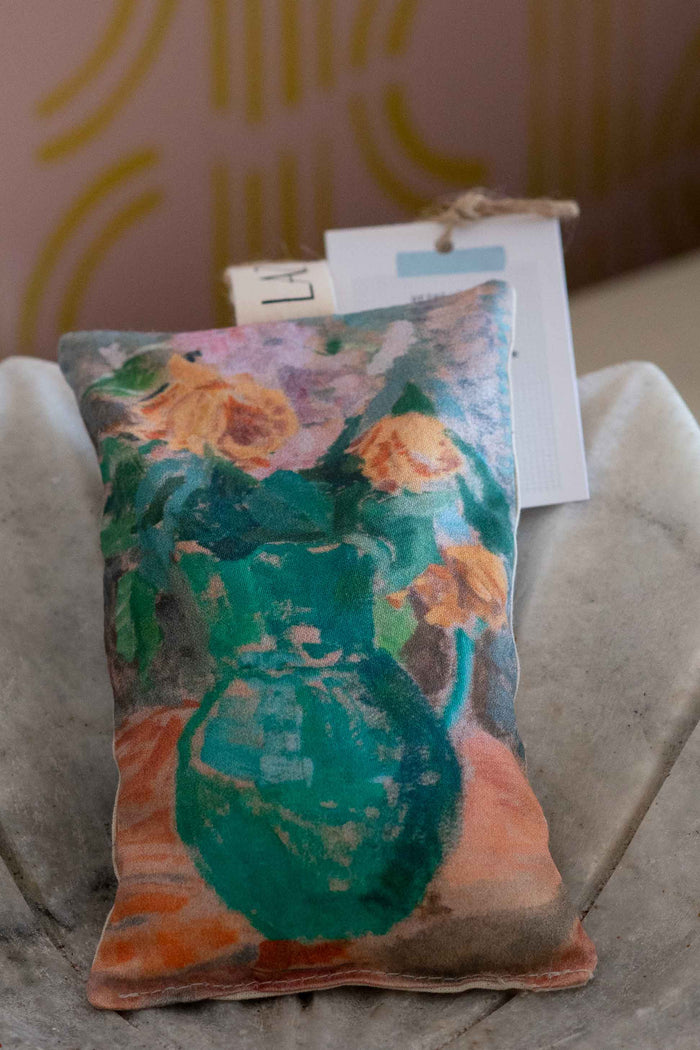 Scented sachet with floral art of a green pitcher and roses.