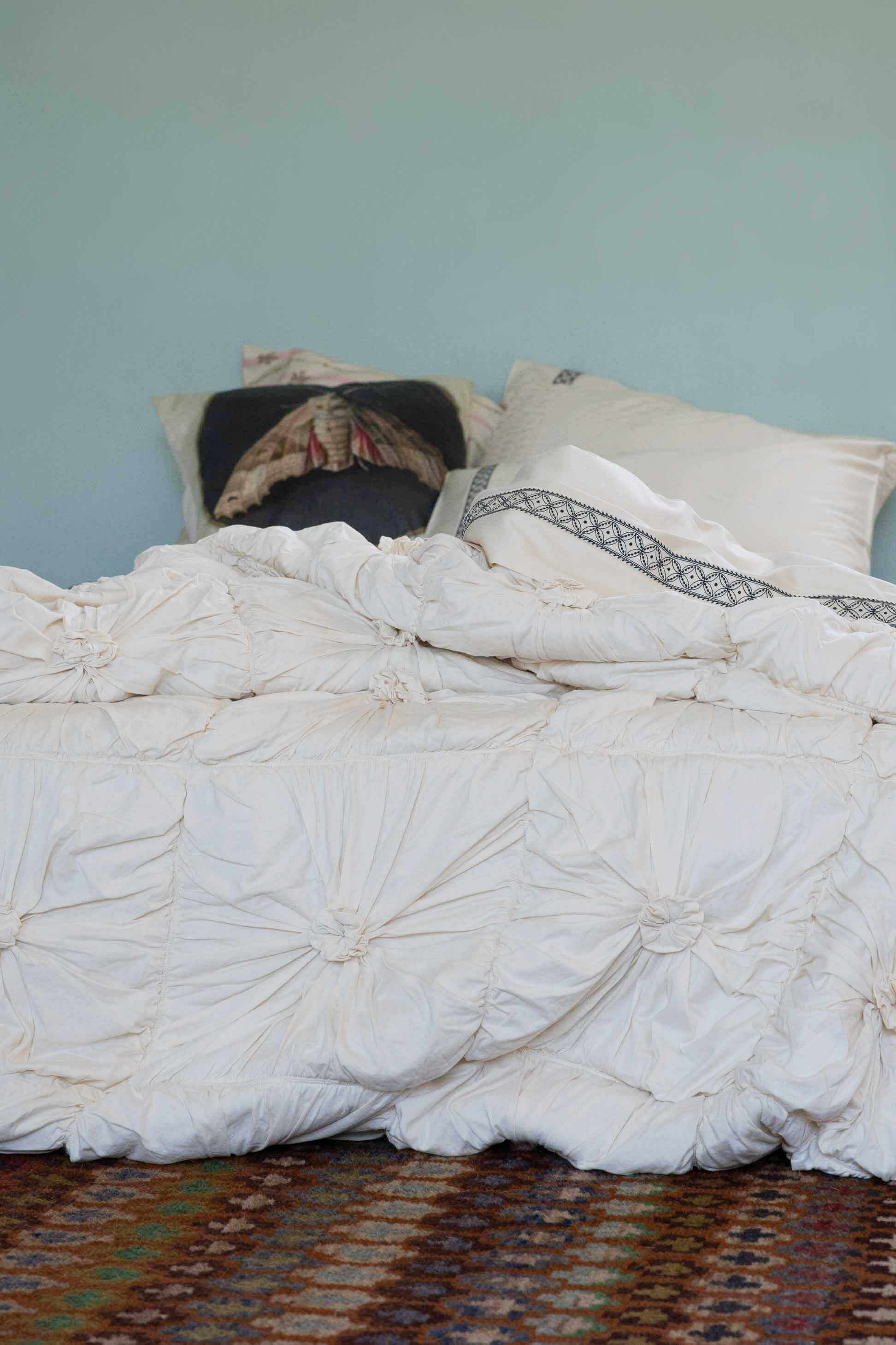 Rosette Natural La Belle Sheets Moth Cushion on bed