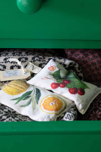 Scented sachets with fruit designs in a green drawer.