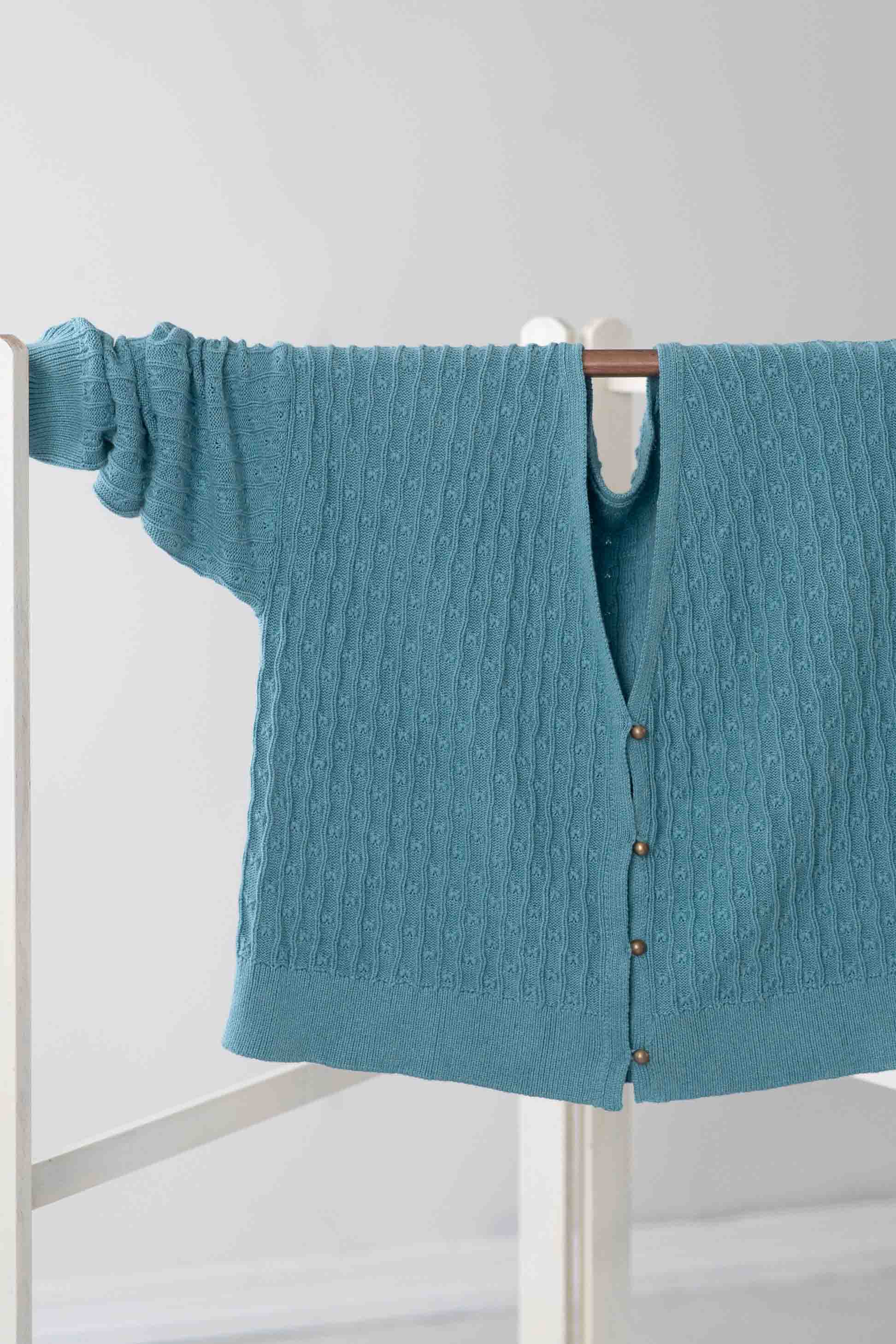 Sunday Cardigan Marine blue cable knit sweater hanging