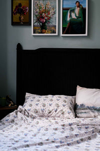 Floral pillowcase and art prints on bed