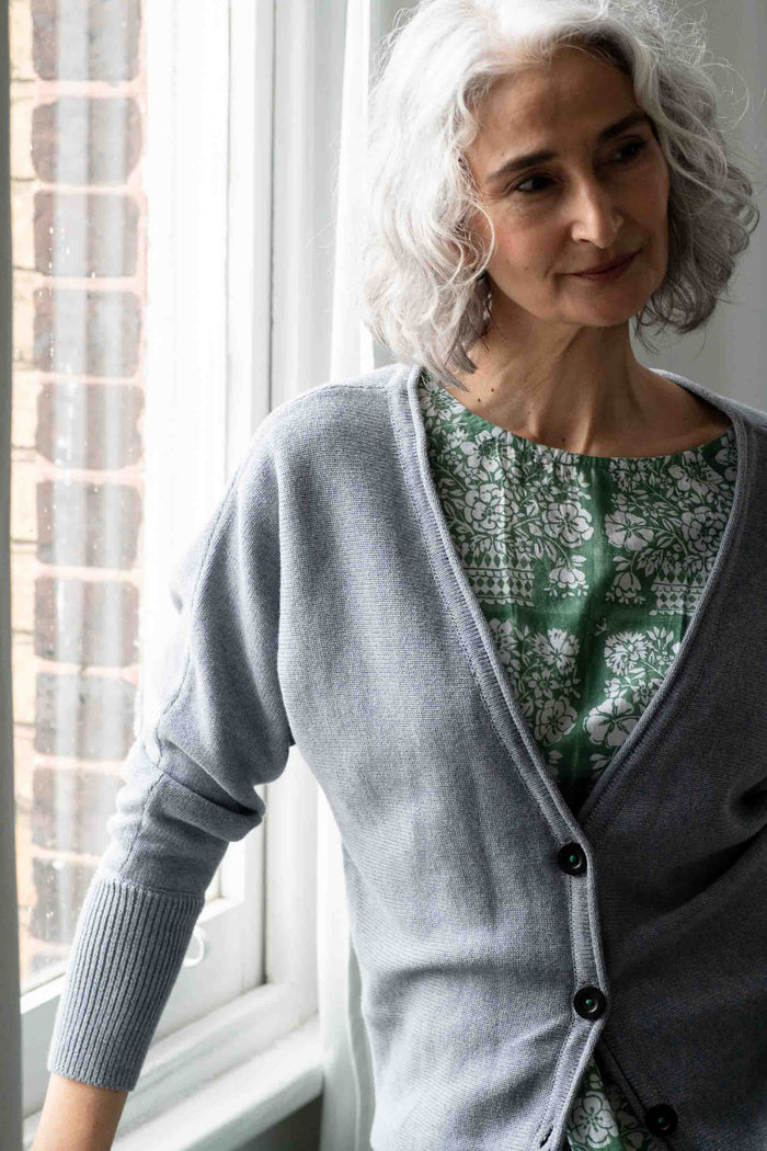 Woman in Willa Chambray cardigan near jasmine flower baskets