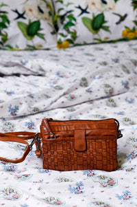 Woven leather bag on floral bedding