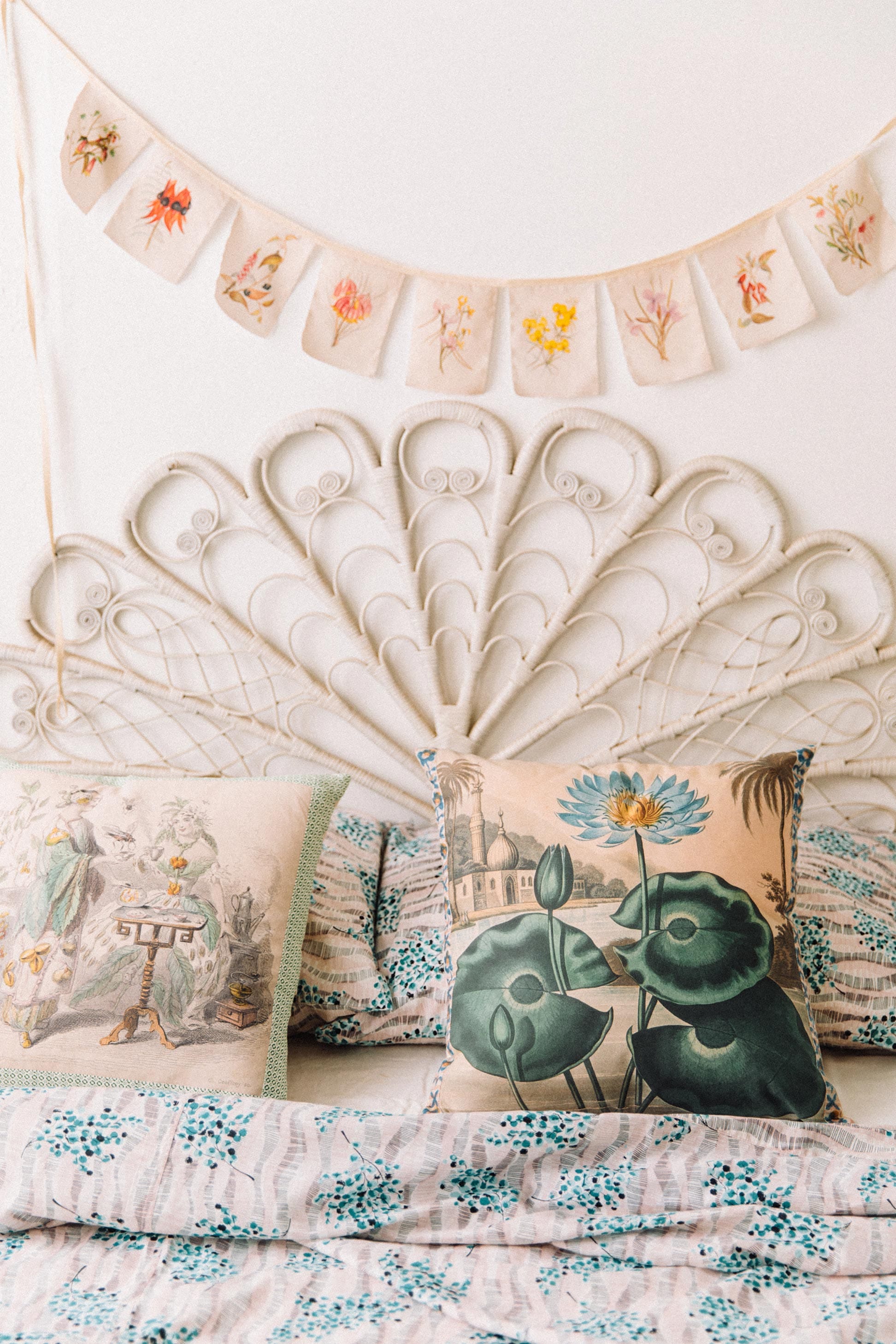 Summer floral cushions and garland on bed