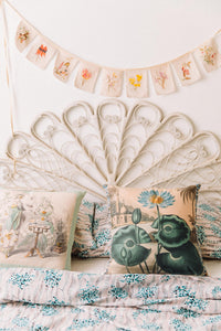 Summer floral cushions and garland on bed