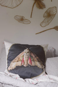 Moth cushion cover on grey bed with Vienna sheet set and pillowcase.
