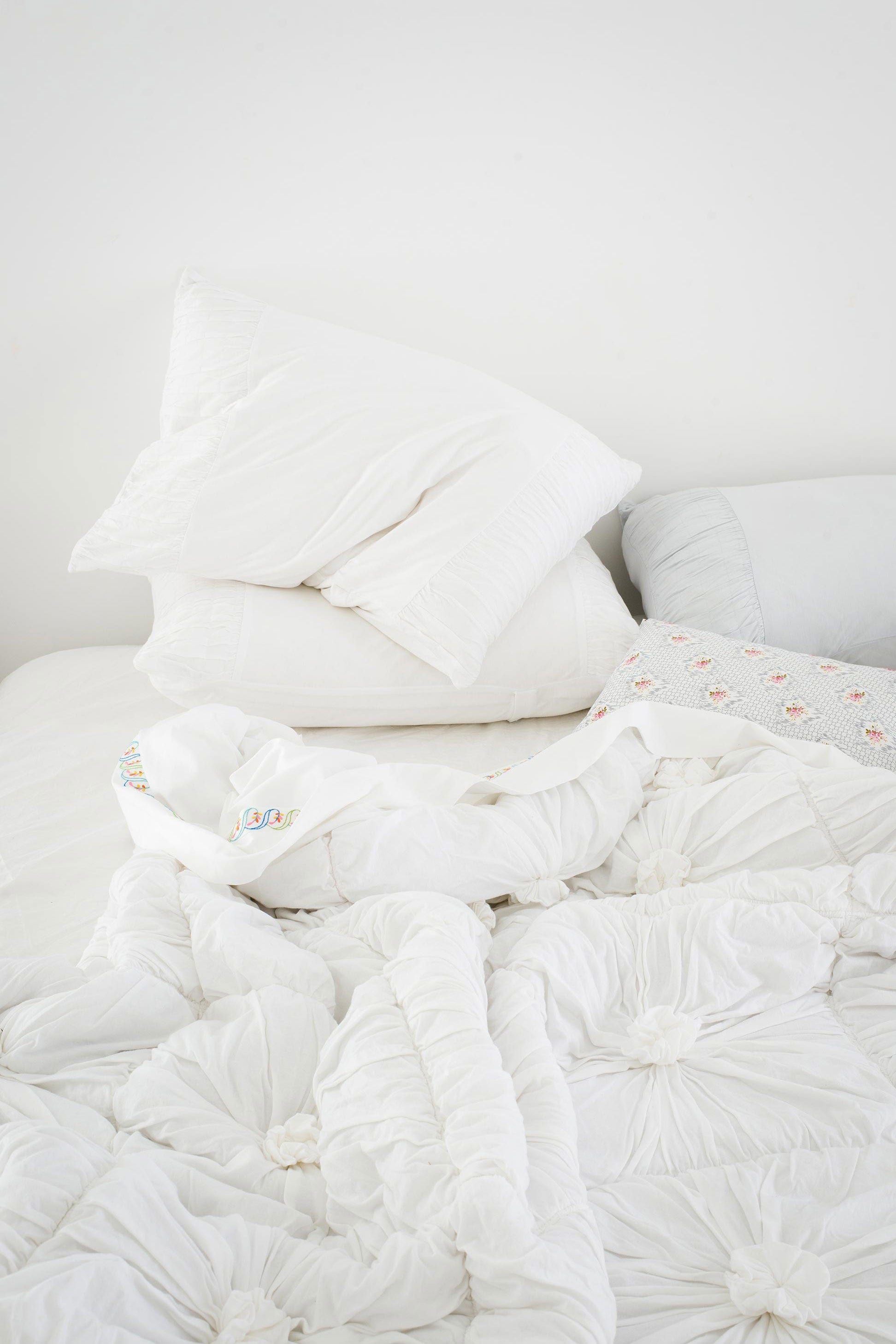 White quilt, pillows, and sheet set on a bed