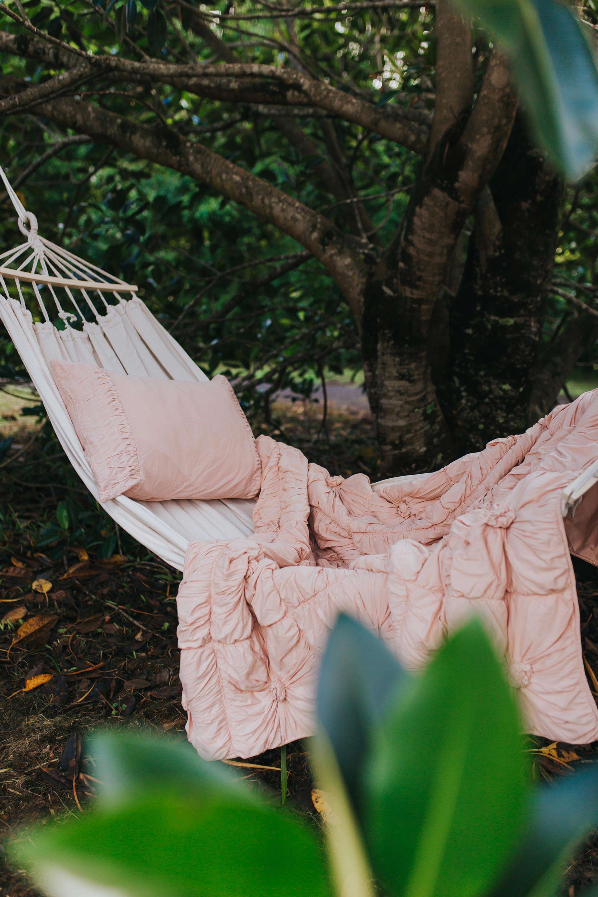 Pink quilt and pillow on hammock in garden