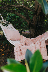 Pink quilt and pillow on hammock in garden